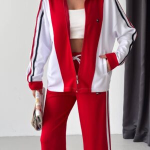 Vista cercana de una chaqueta roja con cremallera, mangas blancas, rayas de manga oscuras y pantalón rojo a juego - Mayorista turco.