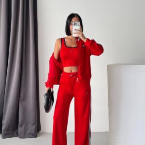 Red zip jacket, cropped tank, and wide-leg pants with striped side detailing.