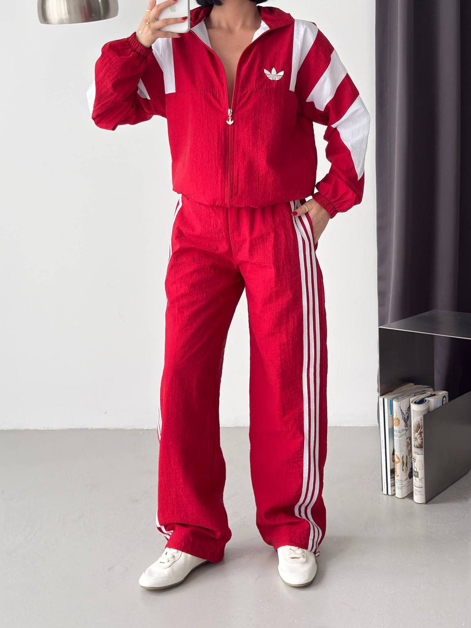 red-tracksuit-front-9052 Red zip-up jacket with white shoulder and sleeve panels paired with matching wide-leg trousers featuring white side stripes.