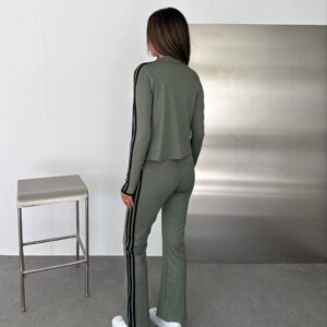 Rear view of a sage jacket and flared trousers with black stripes running along the sleeves and legs.